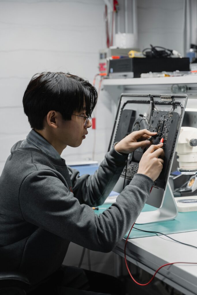 A skilled technician diagnosing and repairing computer hardware indoors.